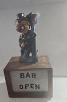 Photo showing front view of the clown figurine on top of the rectangular base with illuminated 'BAR OPEN' sign.