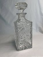 Front view of the square heavy crystal whiskey decanter showing intricate cut glass design and stopper.