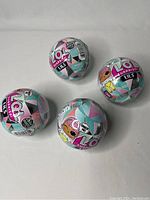 Photo showing four spherical LOL Surprise Lils Winter Disco series unopened packages, arranged on a plain background.