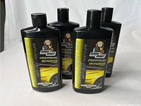 Four black bottles of Shining Monkey car clean and repair treatment, each 473 ml, with yellow and white labels showing a monkey logo.
