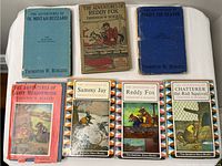 Front cover view of all seven children's books by Thornton W. Burgess showing various illustrated and plain covers.