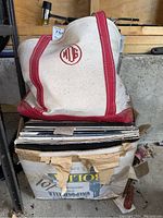 Top view of the box and tote bag containing vintage record albums showing the tote's red trim and MGE logo.