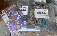 Collection of comic books including Legionnaires 1, Ghosts, and Brothers of the Spear, with soiled sleeves and visible wear.