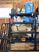 Shelving unit with wood remnants, small tools, General Electric motor, and various containers