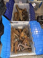Two clear plastic bins filled with assorted rusty hand planes and plane parts