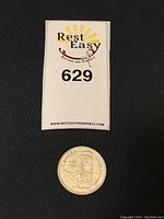 Photo of the 1958 Canadian silver dollar coin below an auction lot card.