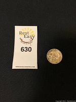 Photo shows the 1958 Canadian silver dollar coin next to a Rest Easy Auctions and Removals tag for scale.