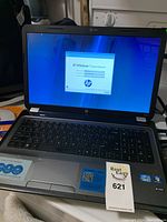 Laptop open with Windows 7 Home Premium installation screen and visible keyboard and palm rest region.