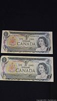 Front view of two 1973 Canadian one dollar bills showing the Queen Elizabeth II portrait, denomination, and coat of arms in color.