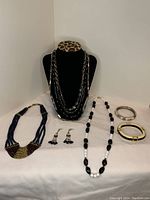 Full view of all costume jewellery items together on white surface, showing variety of necklaces, earrings, and bracelets.