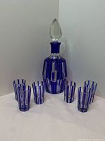Full set showing decanter with stopper and six shot glasses on white background