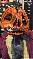 Close-up of the pumpkin head with detailed carvings and expressive eyes.