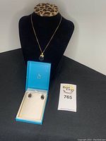 Full view of necklace on display bust with earrings in a blue box, showing the set together and card number.
