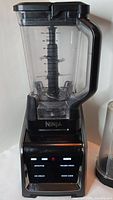 Full view of the Ninja blender showing clear plastic jar with handle, black base, and digital controls.