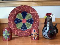 Hand blown glass rooster displayed with Susan Winget ceramic plate and two colorful ceramic salt and pepper shakers.