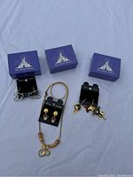 Full lot showing three sets of Disney earrings and one necklace, all with matching blue Walt Disney World boxes.
