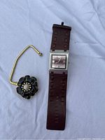 Roots brand wristwatch with brown leather strap and decorative purse holder with black enamel flower