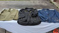 Three women's jackets laid flat: green, black, and denim
