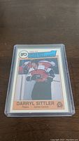 Front photo of the 1983-84 OPC Darryl Sittler hockey card showing the player in Flyers uniform and card design details.