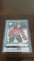Front of Jesper Bratt YoungGuns rookie hockey card showing player in New Jersey Devils uniform in protective case.