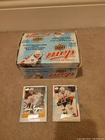 Box of 2008-09 Upper Deck MVP Hockey Cards with two displayed cards featuring Patrice Bergeron and Miikka Kiprusoff, showing front design and player images.