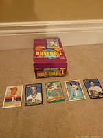 Photo of the unopened 1991 Score Baseball Cards retail box with five individual cards displayed in front.