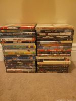 Two stacks of DVD cases showing a total of 38 DVDs including titles from various genres.