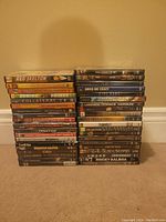 Photo of all 39 DVDs arranged in two stacks, titles visible on the spine, showing variety of movies including The Prestige, Rocky Balboa, Blackbeard, and more.