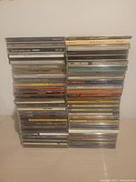 Photo showing two stacks of over 50 CD cases with mostly Latin music titles visible