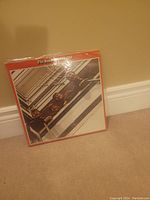 Photo of The Beatles Red Album vinyl record showing the album cover featuring the band and a red border.
