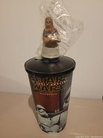 Plastic collectible cup with Star Wars The Force Awakens stormtrooper decal, topped with a wrapped Chewbacca figure on the lid.