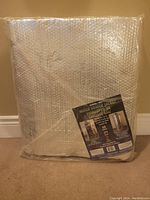 Photo of the water heater jacket still in original sealed packaging showing the product label with specifications and usage instructions.