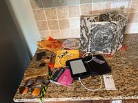 Overview of all items including Kindle, sunglasses, wooden boxes, paper lantern, and other small items on countertop.