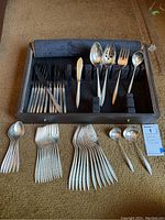 Opened storage case with flatware arranged inside and outside