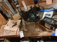 Photo showing WEN Wet Wheel 2901 motor grinder with manual, black face shield, and stands on wooden bench.