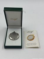 Green Davidoff presentation box open, showing round cutter in white lining and instruction booklet at right