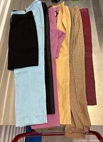 Overview of seven pairs of trousers displayed side by side