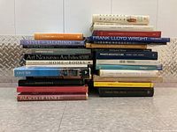 Stack of architecture books and a rolled print on floor