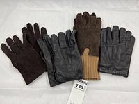 Four pairs of men's gloves displayed flat showing front sides including leather and suede materials in varying shades of brown and black.