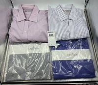 Four folded dress shirts (pink plain, lavender gingham Turnbull & Asser, navy/white striped Creeds, royal blue Creeds) on display