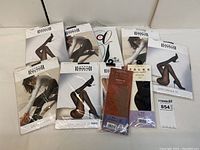 Eight total packs arranged on table, including Wolford, Falke, and unbranded pack