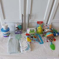 Overview of all baby care and toy items in the lot, including swaddle blankets, wipes, creams and toys.