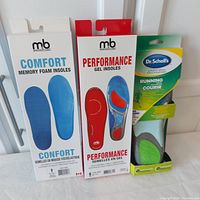 Photo of three pairs of men's insoles in original packaging including M&B Comfort Memory Foam, M&B Performance Gel, and Dr Scholl's Athletic Series Running Insoles.