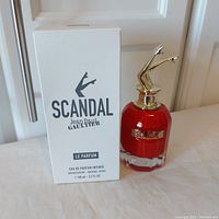 Photo of the perfume bottle beside the plain white tester box showing the front labeling and bottle design.