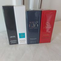Front view of four sealed perfume travel spray boxes side by side
