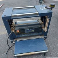 Front view of planer with infeed and outfeed tables extended.