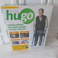 Photo of the boxed Hugo folding walker showing product branding and image of elderly man with walker.