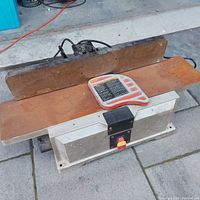 Front view showing infeed and outfeed tables, cutter guard and fence