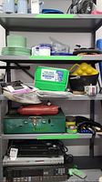Shelf with plates, cups, cooler, camp pot, cutlery, Coleman stove and other camping and workshop items