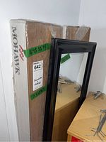 Two packages of Mohawk Jamison Chestnut embossed laminate flooring standing vertically, with labels showing size and square footage.